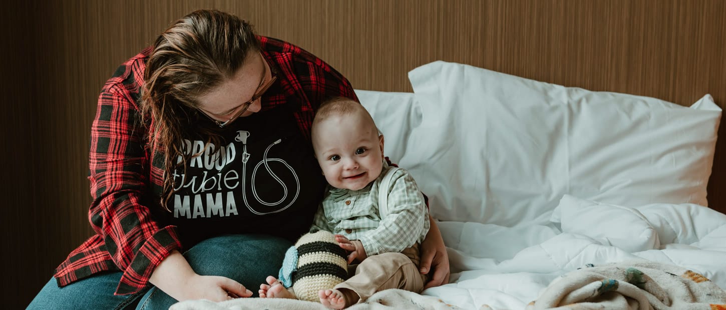 Woman and child sitting on bed